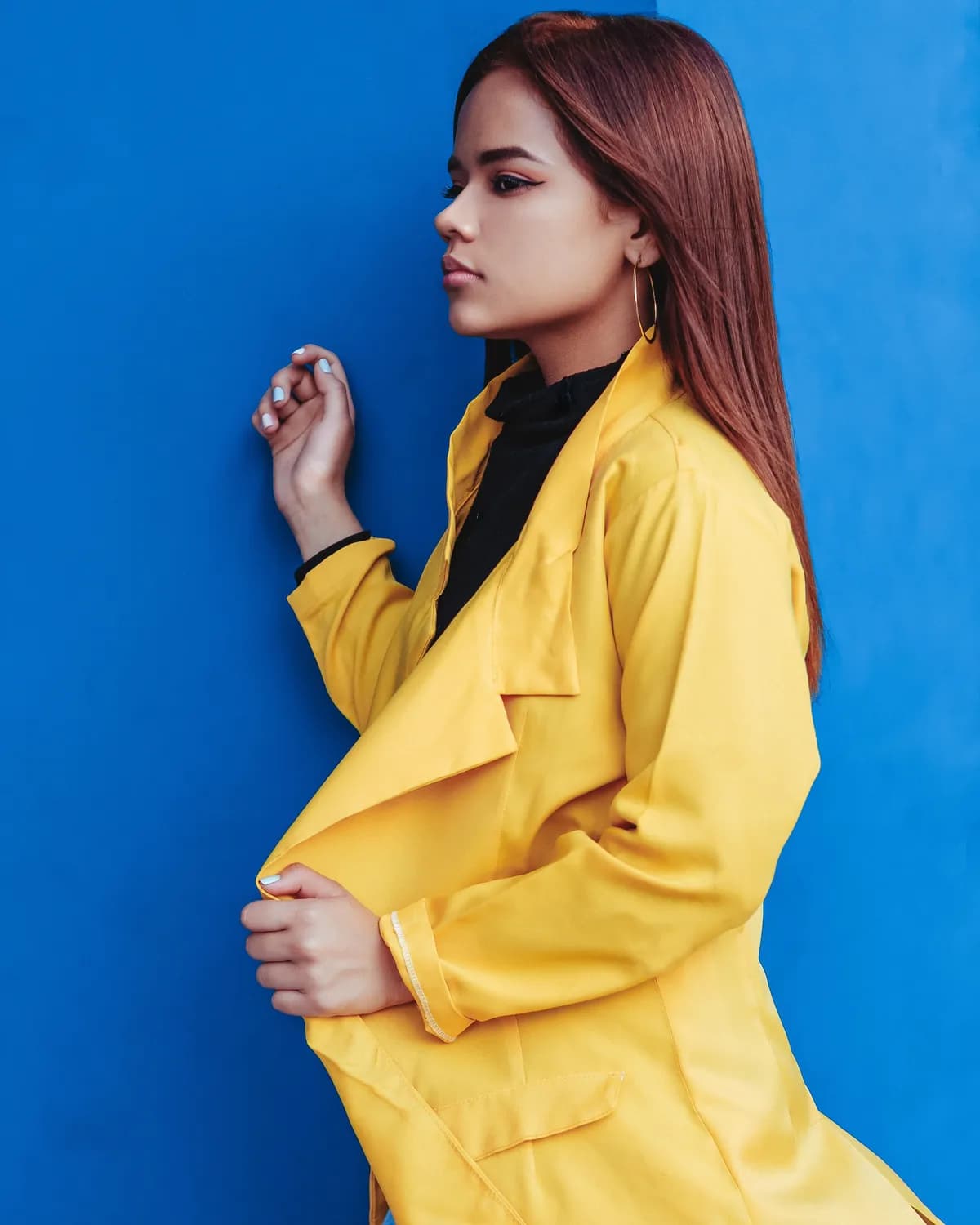 Modelo de casaco amarelo contra fundo azul royal